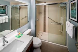 a bathroom with a shower and a toilet and a sink at Hyatt Place Long Island City in Queens