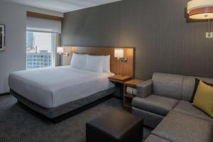 a hotel room with a bed and a couch at Hyatt Place Long Island City in Queens