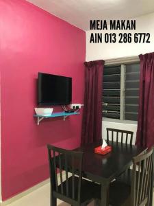 a dining room with a table and a pink wall at Rumah Chewaa Homestay in Kuala Lumpur