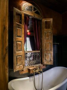 e bagno con finestra e vasca. di Chateau Orientale Resort a Luang Prabang