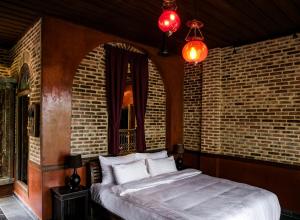 una camera da letto con un letto e un muro di mattoni di Chateau Orientale Resort a Luang Prabang Altre 55 foto