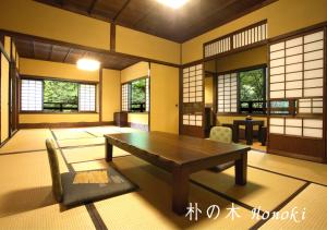 sala de estar con mesa de madera y sillas en Ryokan Sanga en Minamioguni
