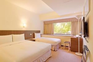 台北的住宿－洛碁大飯店山水閣，酒店客房设有两张床和电视。