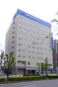 a hotel building with a sign on top of it at Dormy Inn Tsu in Tsu