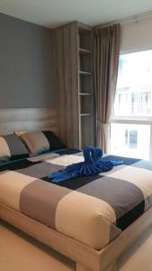 two beds in a bedroom with a window at GrandBlue Condominium 201 in Mae Pim