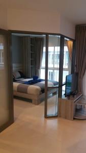 a bedroom with a bed and a television in it at GrandBlue Condominium 201 in Mae Pim