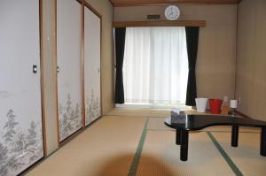 a living room with a table and a window at Tuktuk House in Kawagoe