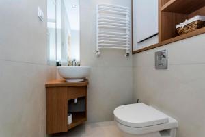 Łazienka z białą toaletą i umywalką w obiekcie Promenada moj-sopot pl w mieście Sopot