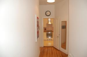 een hal met een klok aan de muur en een keuken bij Home from Home at Number 2 in Edinburgh +2 foto's