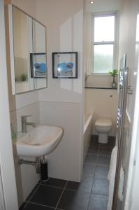 a white bathroom with a sink and a toilet at Home from Home at Number 2 in Edinburgh
