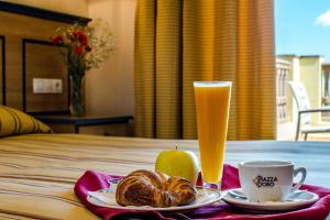 a table with a plate of bread and a glass of beer at Hotel Mirador in Algeciras