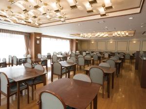a dining room with tables and chairs in it at Hotel New Momiji in Nasushiobara
