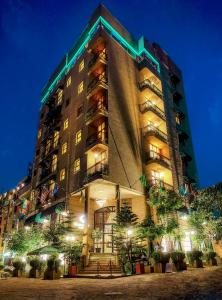 Un grand bâtiment avec des lumières allumées la nuit dans l'établissement Sherar Addis Hotel, à Addis-Abeba