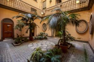 un couloir avec des plantes en pot dans un bâtiment dans l'établissement Dimoro Suite, à Rome