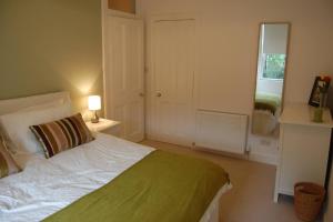 een slaapkamer met een wit bed en een spiegel bij Home from Home at Number 2 in Edinburgh
