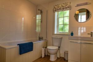 a bathroom with a toilet and a tub and a sink at Broads Reach in Stalham