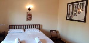 1 dormitorio con 1 cama y una foto en la pared en Raintree Lodge, en Kochi