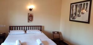 a bedroom with a bed and a picture on the wall at Raintree Lodge in Cochin
