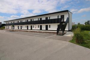 a large white building with a staircase in a parking lot at BG Hotel by WMM Hotels in Bad Grönenbach