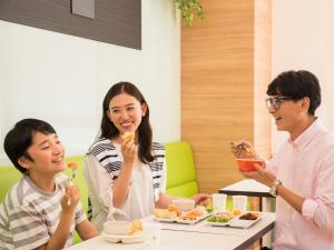 kobieta i mężczyzna jedzący jedzenie przy stole w obiekcie Comfort Inn Omihachiman w mieście Omihachiman