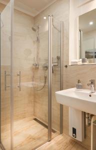 a bathroom with a glass shower and a sink at Am Hafen - Ohlerichspeicher in Wismar