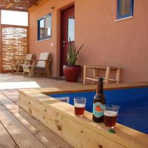una botella de cerveza sentada en una mesa junto a una piscina en Zman Arava en Zuqim