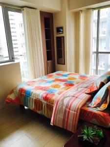 a bedroom with a bed with a colorful blanket at Resorts World Condo in Manila