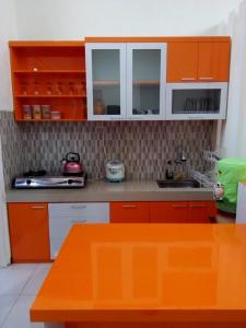 cocina con armarios de color naranja y encimera en Vila Monex en Batu