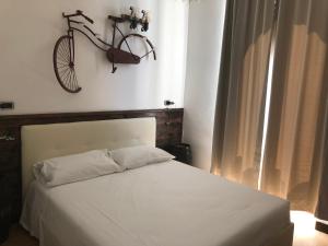 - une chambre avec un lit et un vélo suspendu au mur dans l'établissement Torre Balzano B&B, à Valenzano