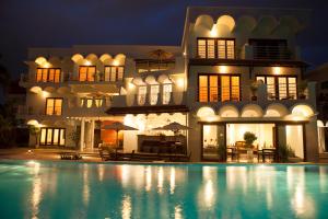 a hotel with a swimming pool in front of a building at iRoHa Garden Hotel & Resort in Phnom Penh