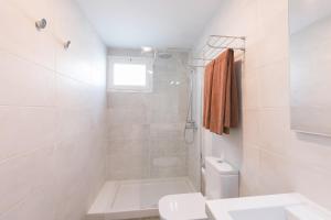 a white bathroom with a shower and a toilet at Apartamentos Celeste in Costa Teguise