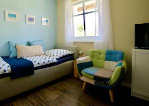 ボルンにあるHaus Meerblauのベッドルーム1室(ベッド1台、椅子、窓付)