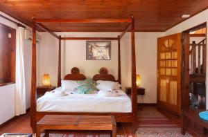 um quarto com uma cama de dossel em madeira em La Villa Mille Etoiles em Baie Sainte Anne