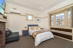 a bedroom with a bed and a chair at Marulan Stayz in Marulan