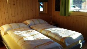 2 Betten in der Ecke eines Zimmers in der Unterkunft Chalet Edi in Münster VS