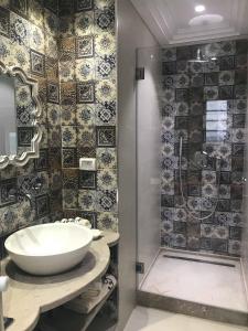 a bathroom with a sink and a shower at Dar Corniche La Marsa (Adults Only) in La Marsa