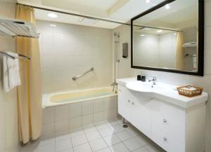 a bathroom with a sink and a tub and a mirror at Green Garden Apartments-A in Taipei