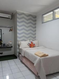 1 dormitorio con 1 cama con pared a rayas en Cihampelas Homestay, en Bandung
