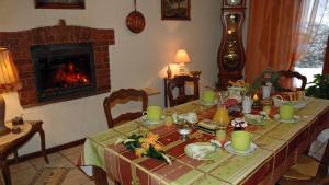 einen Esstisch mit einem Kamin und einem Tisch mit grünen Gerichten in der Unterkunft Chambres d'hôtes La Hulotte 69 in Villechenève