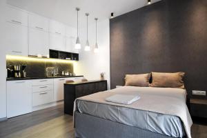 a bedroom with a large bed and a kitchen at Nest Apartment in Athens