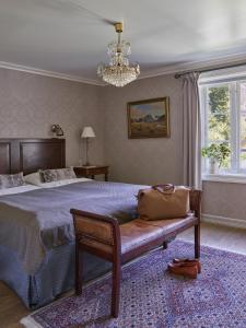 
a bedroom with a bed, chair, lamp and window at Fretheim Hotel in Flåm
