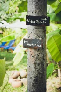 a pole with two signs on a tree at iRoHa Garden Hotel & Resort in Phnom Penh