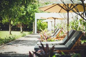 a group of chairs and umbrellas in a garden at iRoHa Garden Hotel & Resort in Phnom Penh