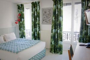 1 dormitorio con 1 cama y una ventana con cortinas en Hôtel du Temps, en París