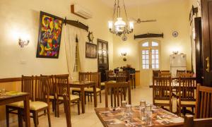 a dining room with tables and chairs in a restaurant at Prazeres Boutique Hotel in Panaji
