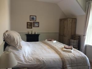 a bedroom with a large bed with two towels on it at Crown and Anchor in Dundrennan