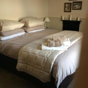 a bedroom with a large bed with towels on it at Crown and Anchor in Dundrennan