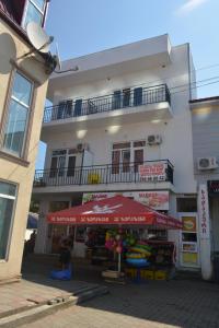 a store with a red umbrella in front of a building at hotel niks in Makhinjauri