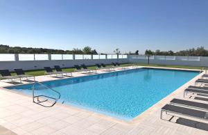 ein großes Schwimmbecken mit Stühlen in der Unterkunft Varchotel in Elvas
