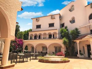 a large white building with tables and chairs at Varchotel in Elvas